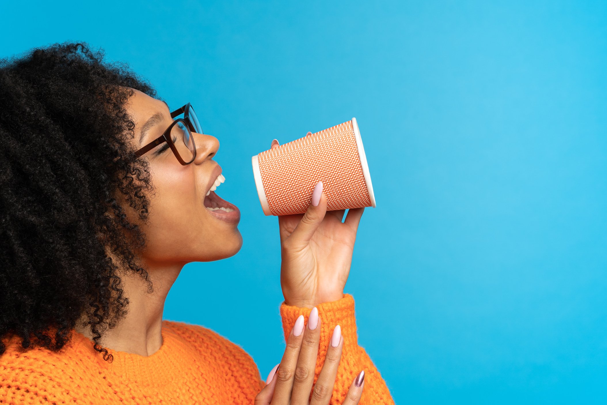 Young Girl Announces Black Friday in Paper Cup as Megaphone